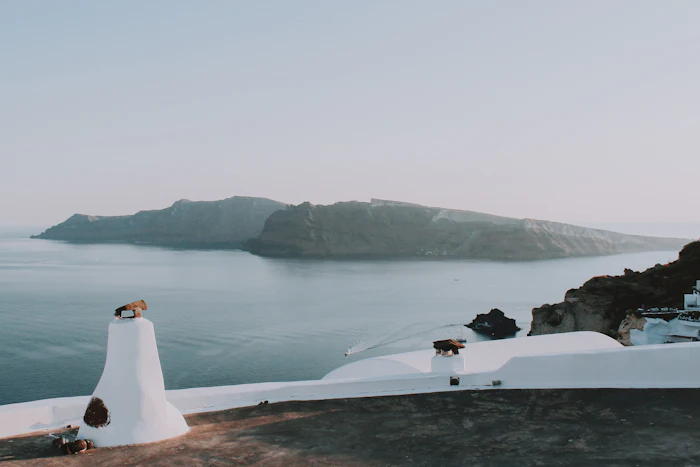 Couple in flowing outfits at a Santorini caldera picnic