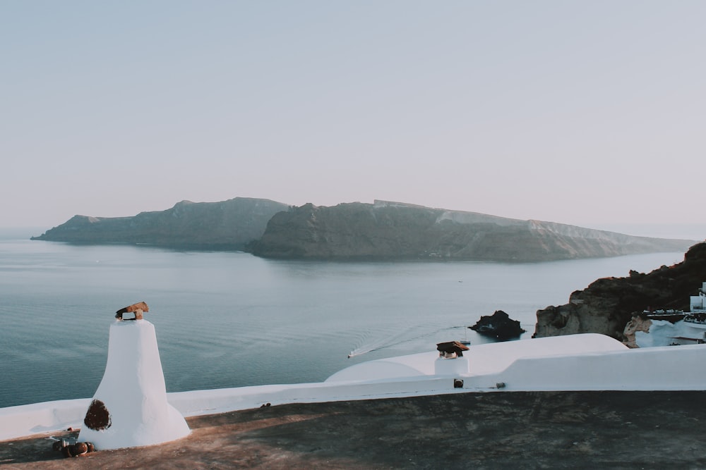 white painted wall overlooking sea and mountain