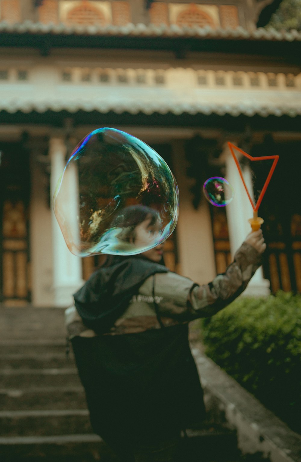 Femme tenant une machine à bulles en plastique orange pendant la journée