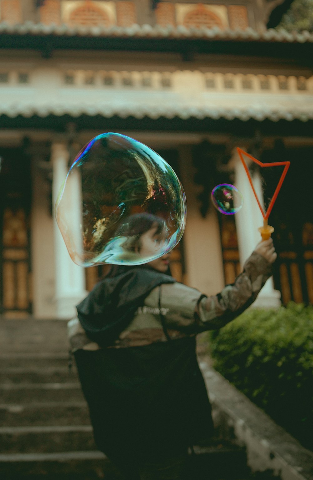 Donna che tiene il creatore di bolle di plastica arancione durante il giorno