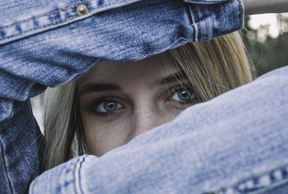 selective focus photography of woman wearing blue denim jacket