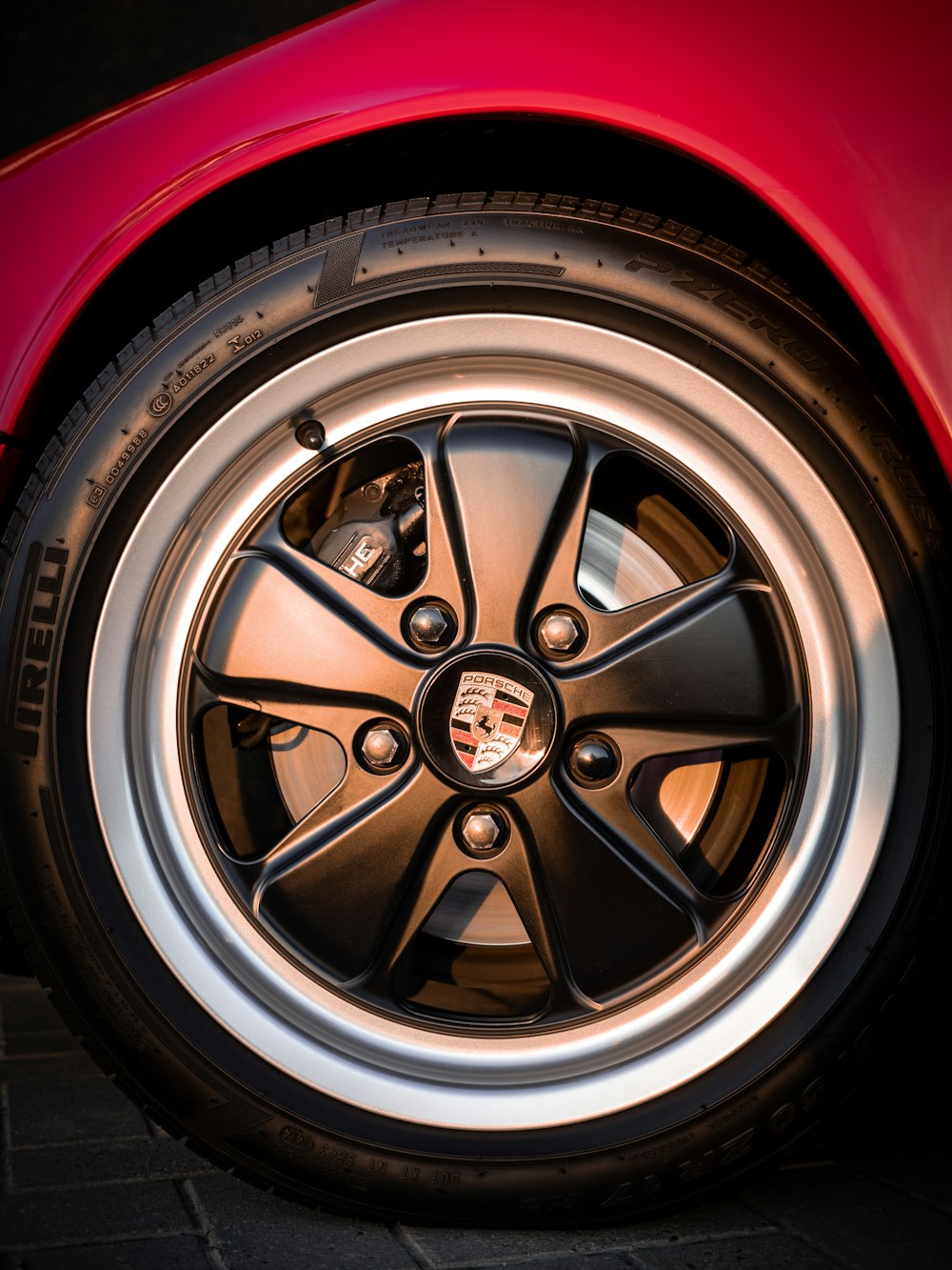black Porsche wheel with tire red car