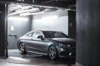 Sleek luxury car parked in a dimly lit modern garage with golden accents.