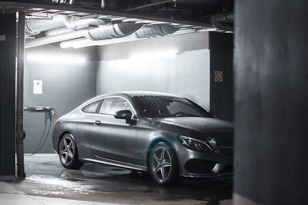Sleek industrial luxury garage interior with high-contrast lighting and premium car detailing.