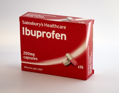 A red box of Sainsbury's Healthcare Ibuprofen is displayed, featuring large white lettering indicating 'Ibuprofen' and '200mg capsules' along with an illustration of a capsule. The label also mentions 'Effective pain relief' and the box contains 16 capsules.