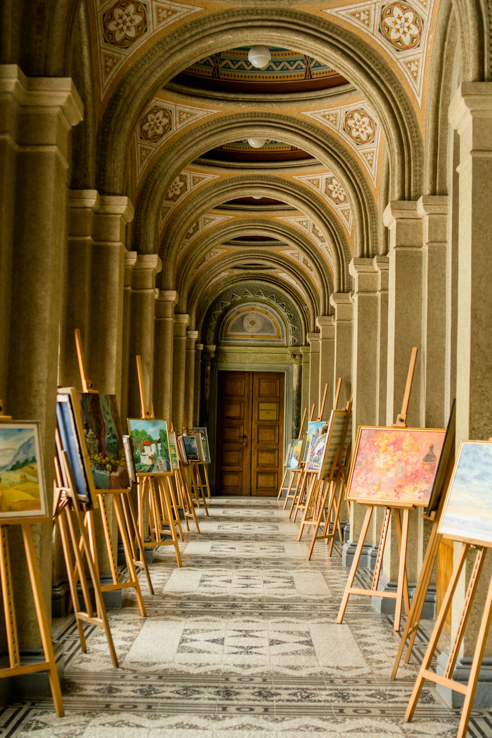 brown wooden paint easel with varieties of paintings