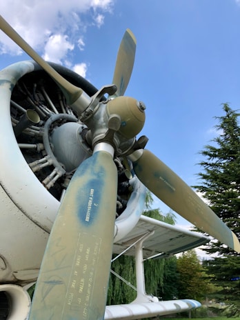 Close-up of a vintage airplane propeller gleaming under clear blue skies.