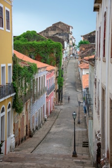 person on road walking between buildings during daytime