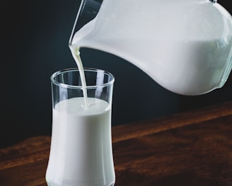 person pours milk into glass