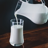 person pours milk into glass