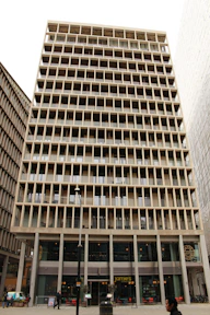 A high-rise business center building with glass facade in urban setting.