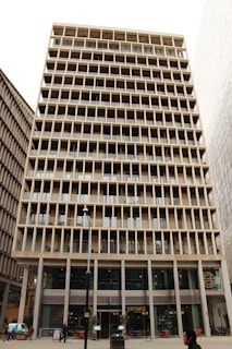 A modern high-rise building with glass facades in an urban setting.