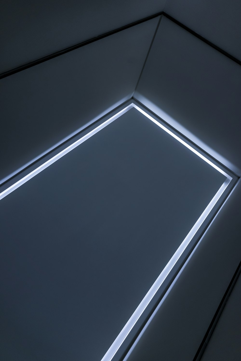 a corner of a room with a light coming from the ceiling