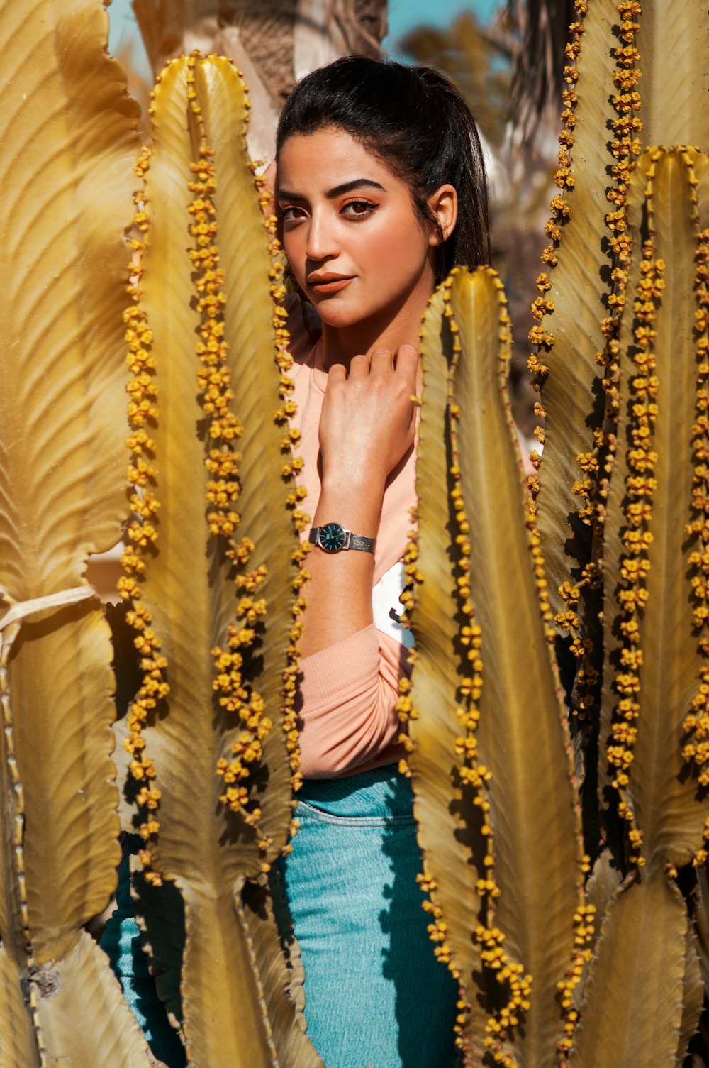 woman in middle of beige and green leaf plants during daytime