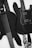 Two black guitars are visible, one bass guitar with four strings and one electric guitar with six strings. Both instruments rest against a light background, emphasizing their sleek design. The guitar straps have intricate patterns, adding a touch of personal style.