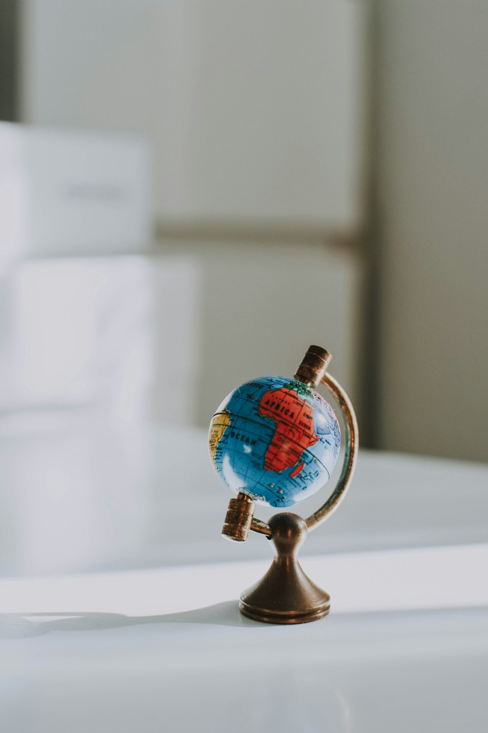 un petit globe posé sur une table blanche