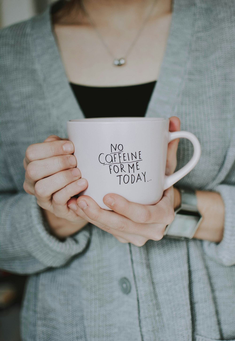 woman holding white cup