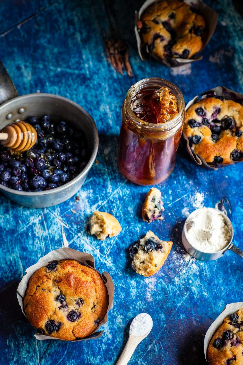 Heidelbeeren auf grauer Schüssel und Muffins