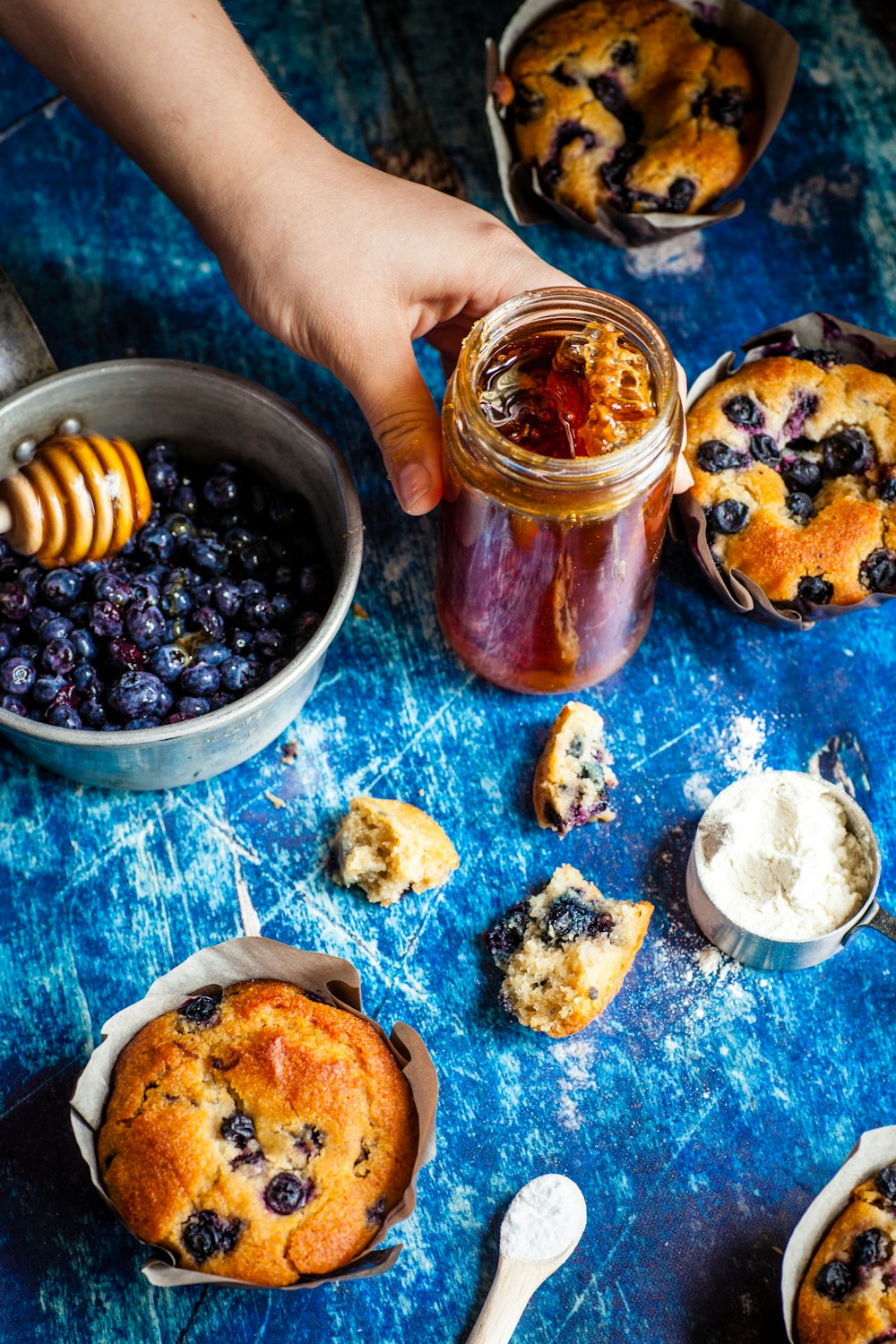 person holding glass jar with honey