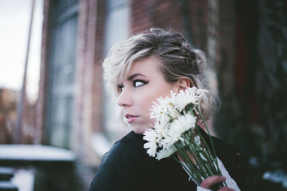 woman holding white mums flowers