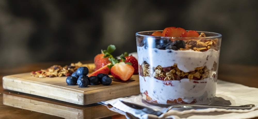 strawberries and cookies with cream filled dessert in glass cup