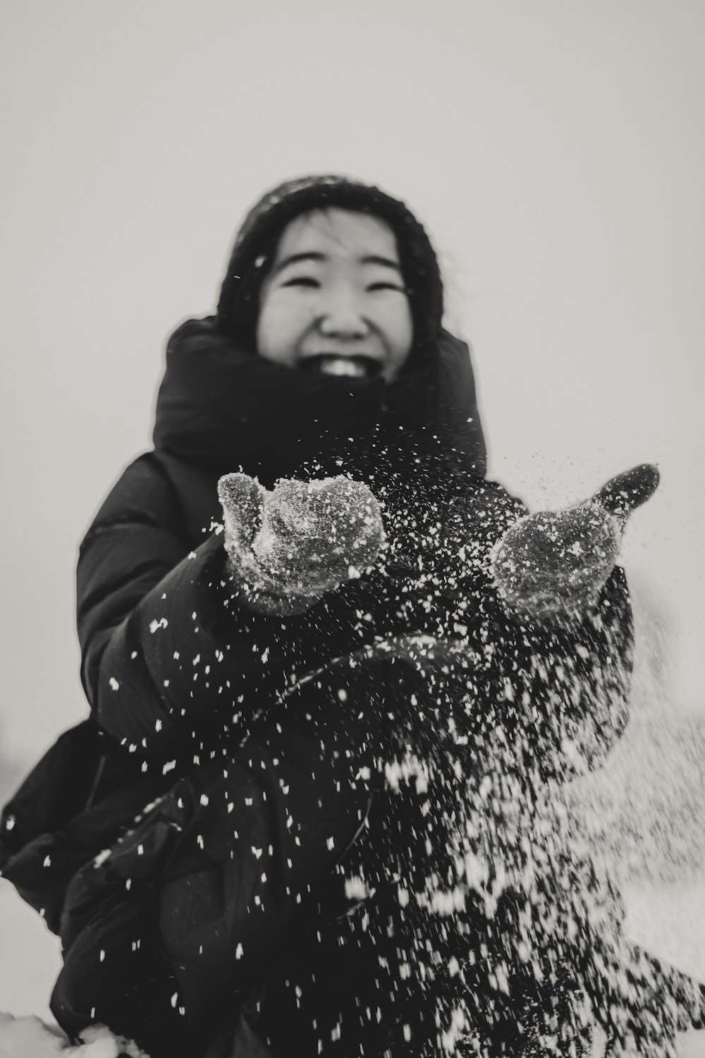 grayscale photography of woman playing with snow