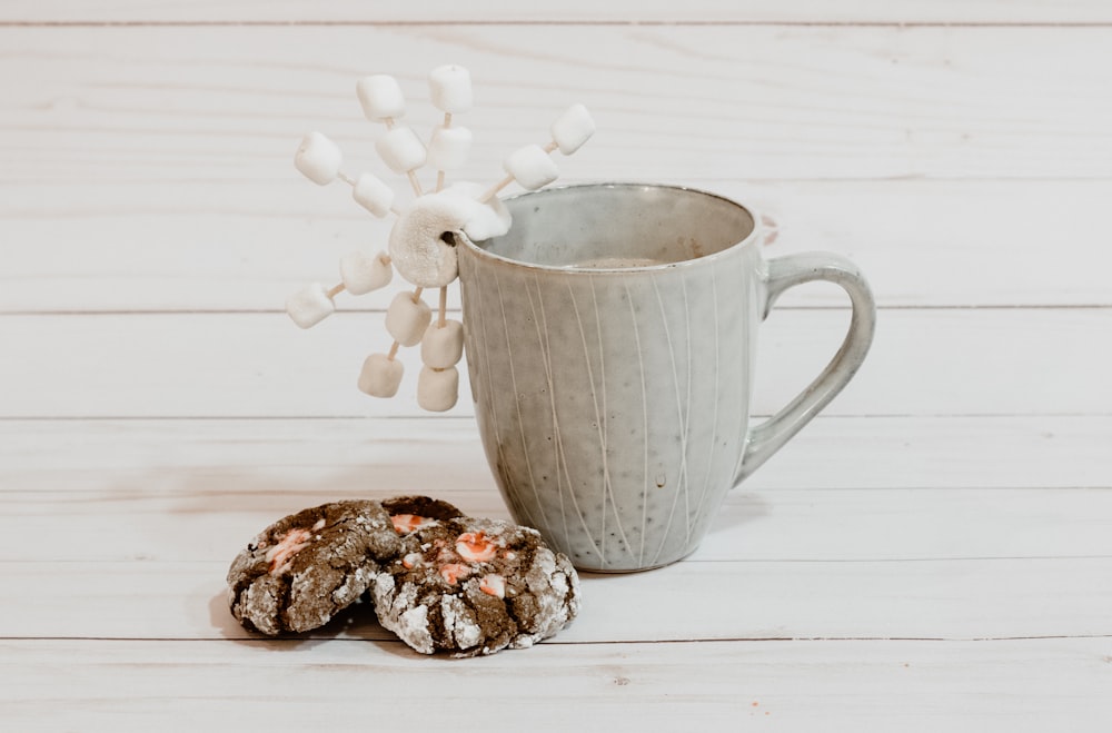 Caneca de cerâmica cinza na superfície de madeira branca