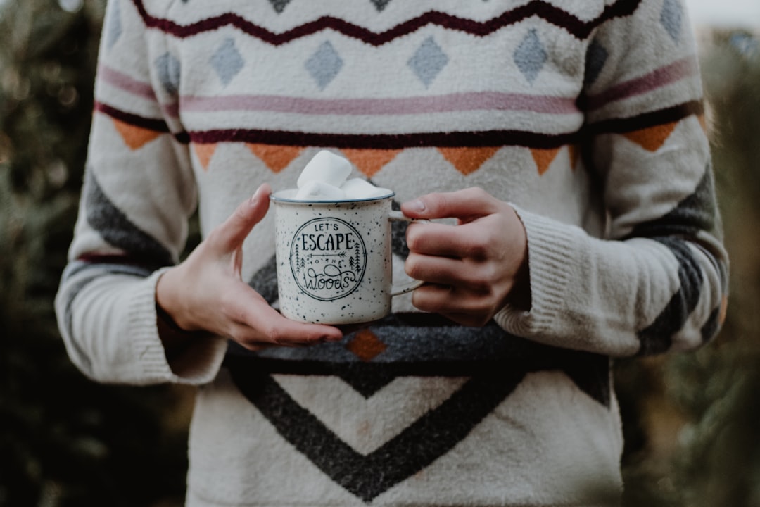 person holding mug with marshmallow