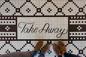 Couple wearing stylish fleece garage shoes standing on ceramic tiles.