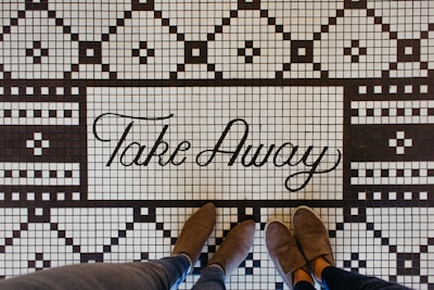 Couple wearing stylish fleece garage shoes standing on ceramic tiles.