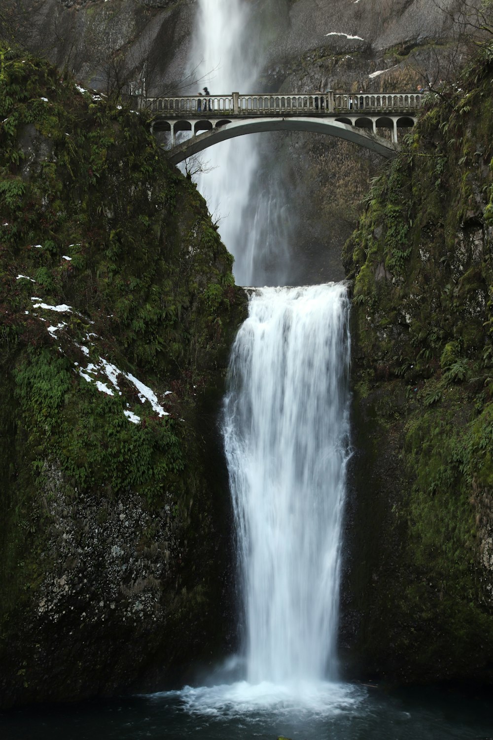 Puente gris sobre cascadas de agua