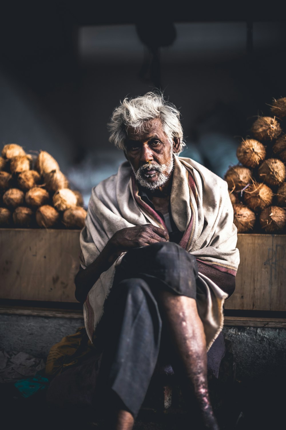 man sitting beside coconut stand