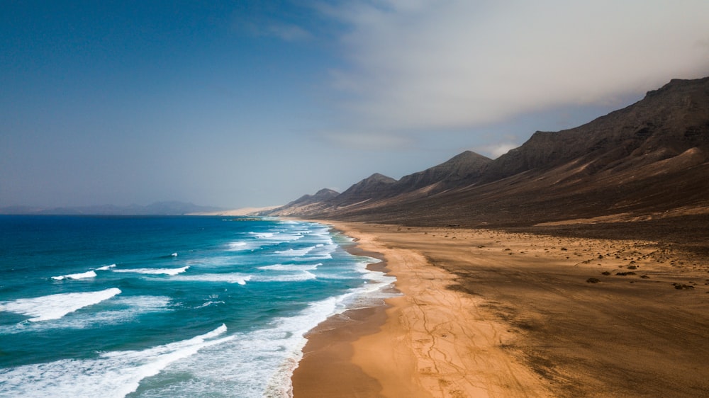 mountain beside sea at daytime