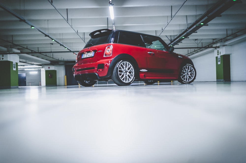 red 3-door hatchback on building parking lot