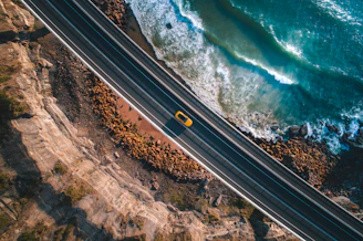 A Jetour crossover cruising along a coastal highway with waves crashing nearby.