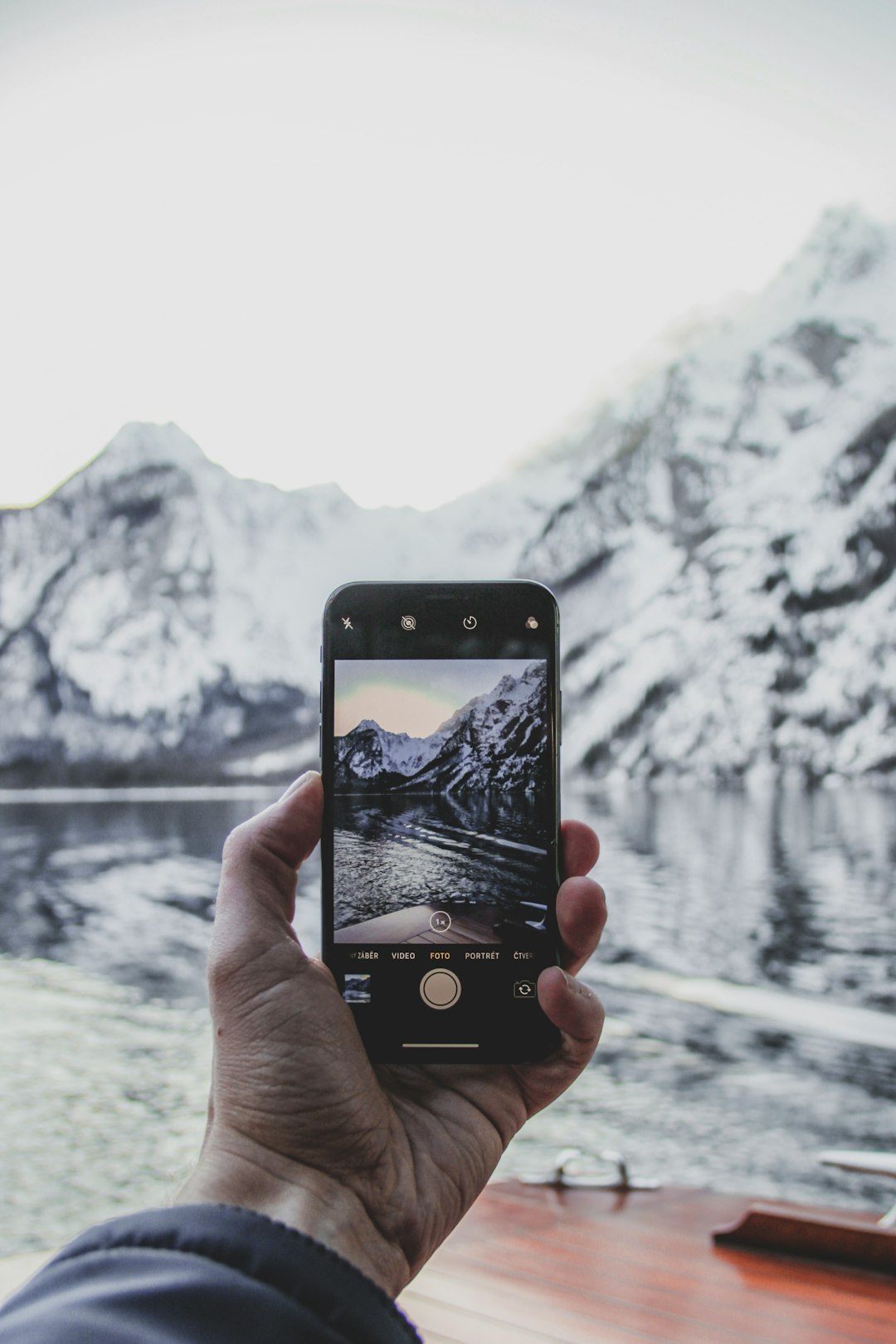 person taking photo of lake