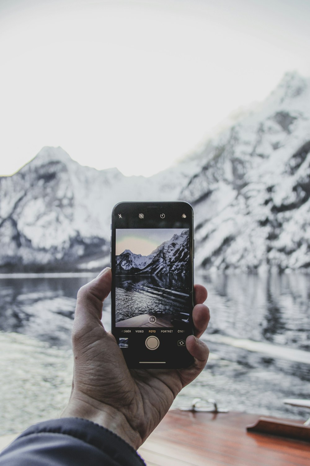 person taking photo of lake