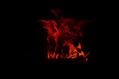 A glowing stylized flame surrounded by sacred geometric patterns in warm golden and red tones.