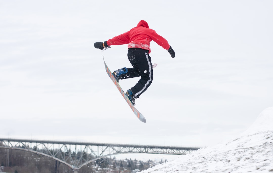 person jumps while in snowboard