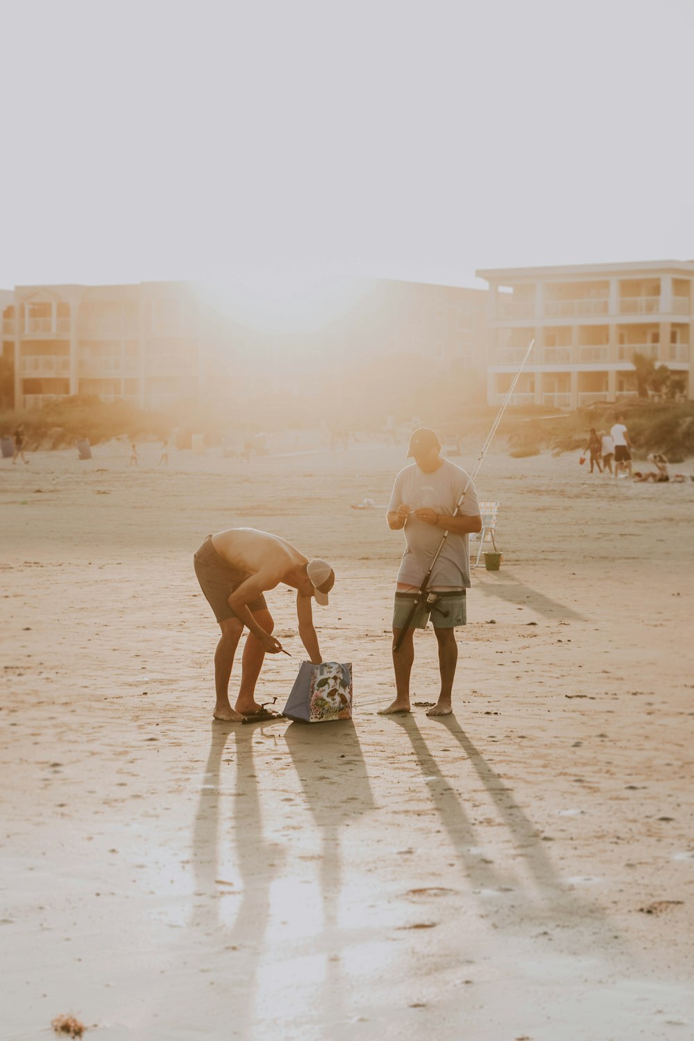 a couple of men standing on top of a sandy beach