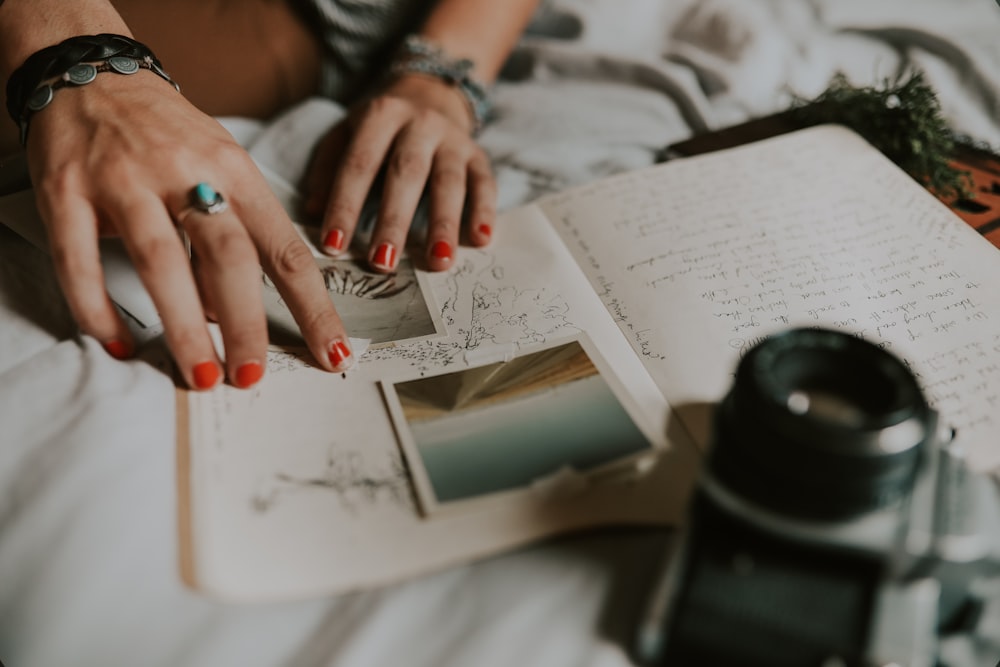 person with hand on notepad page with pictures and writing