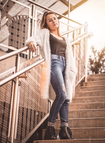 A model posing confidently on a rooftop at sunset wearing boldstepswear's avant-garde coat with sculptural details.