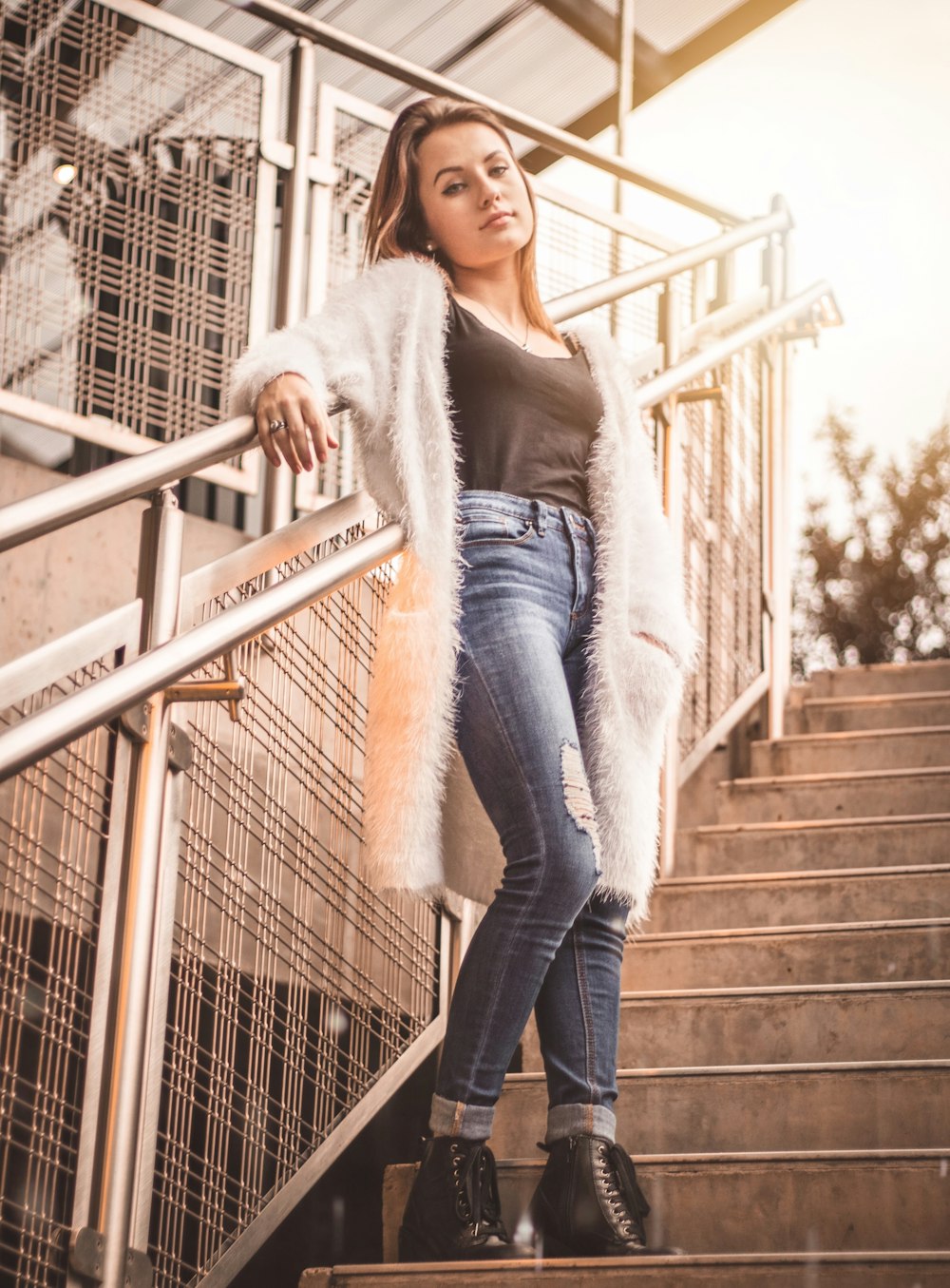 woman leaning on handrail while standing on stairs