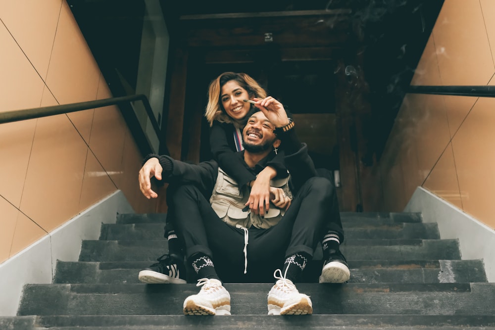 man and woman hugging each other white sitting on black staircase