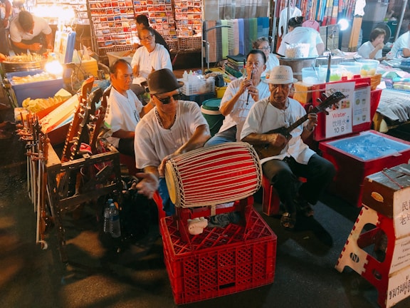 A lively street scene in Belize with musicians playing reggae under colorful market tents.