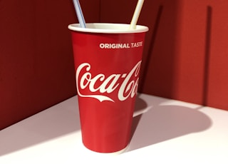 Coca-Cola disposable cup on top of white table