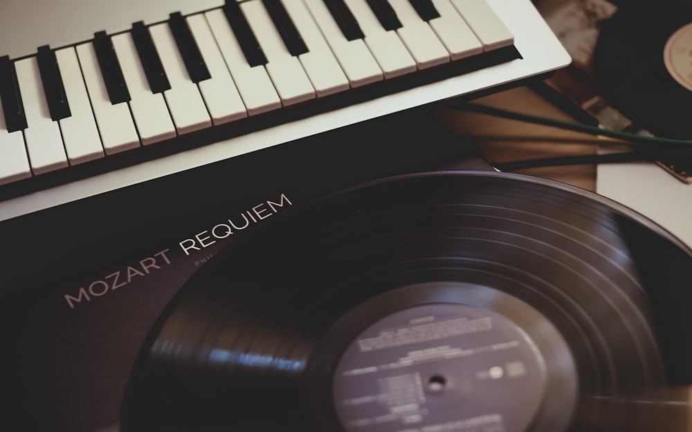 Disco de vinilo cerca del teclado electrónico blanco