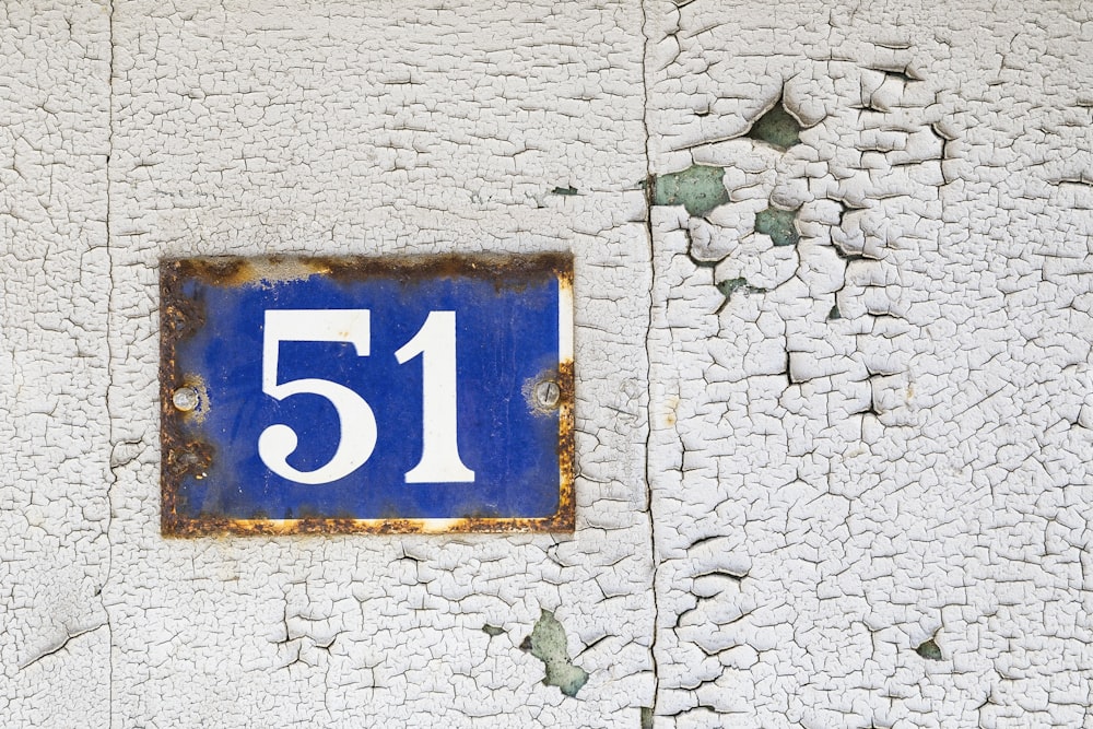 a blue and white sign on a white wall