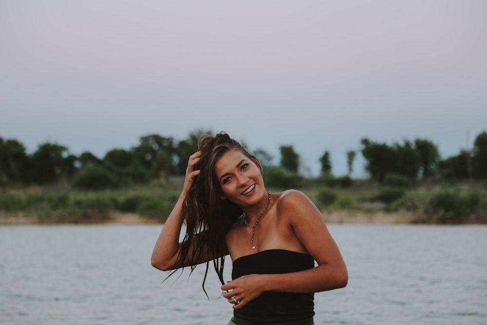 woman wearing black strapless tops near body of water