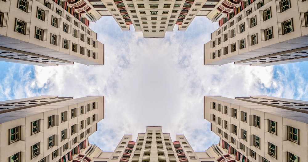 low angle photography of two white concrete buildings